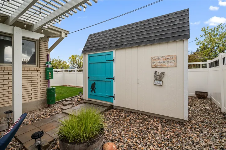 View of shed featuring a fenced backyard and a pergola