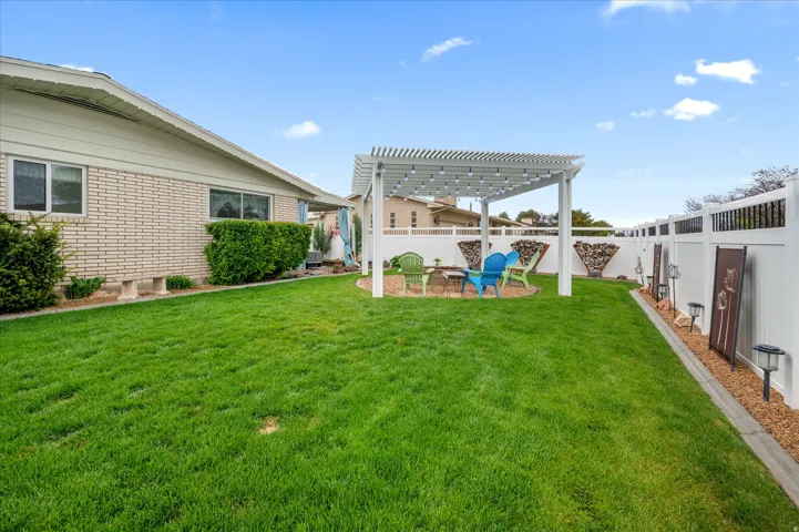 Fenced backyard with a pergola, a playground, and a patio