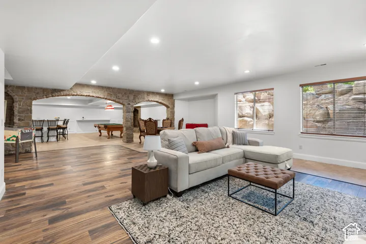 Spacious lower-level living area with recessed lighting, wood-finish flooring, and white walls