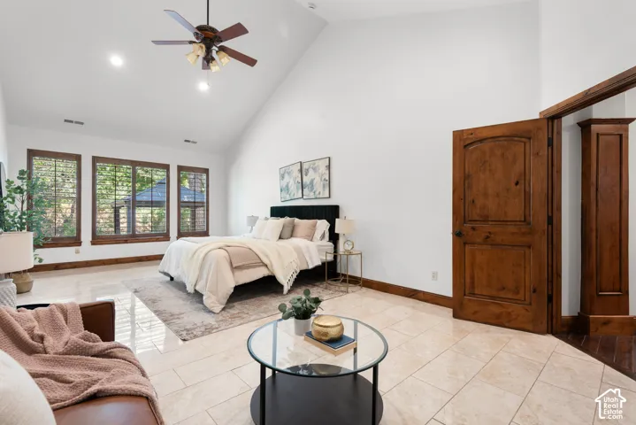 Spacious room featuring vaulted ceilings, a ceiling fan, and recessed lighting