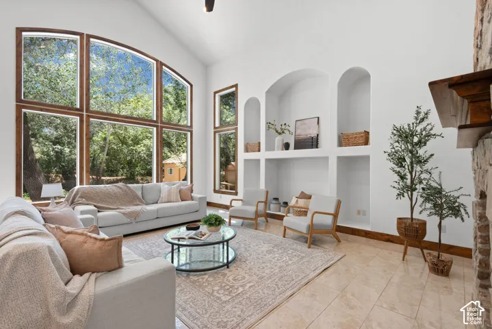Living space featuring high ceilings and large windows with wood-finish framing