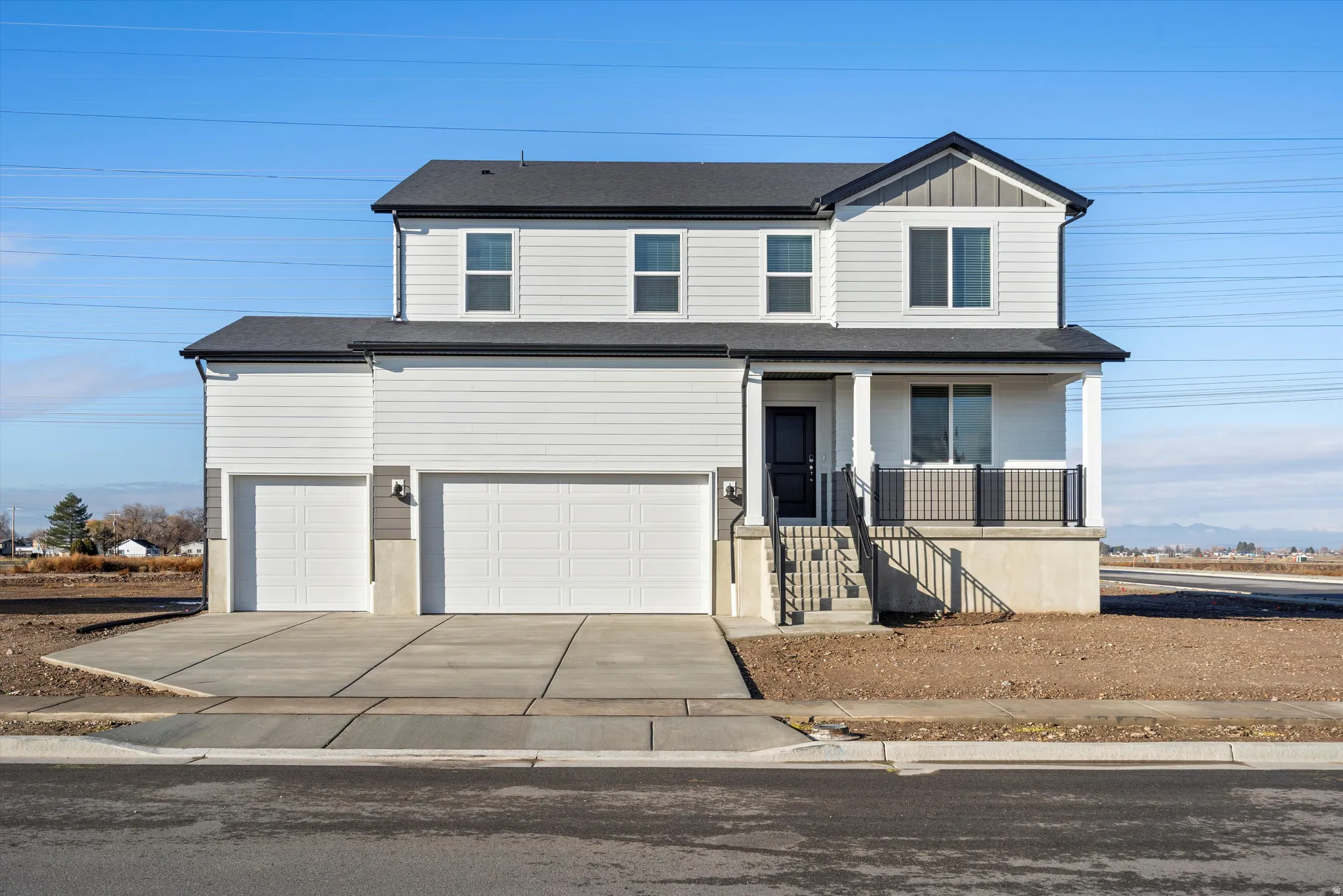 View of front of property with covered porch, driveway, a garage, and board and batten siding