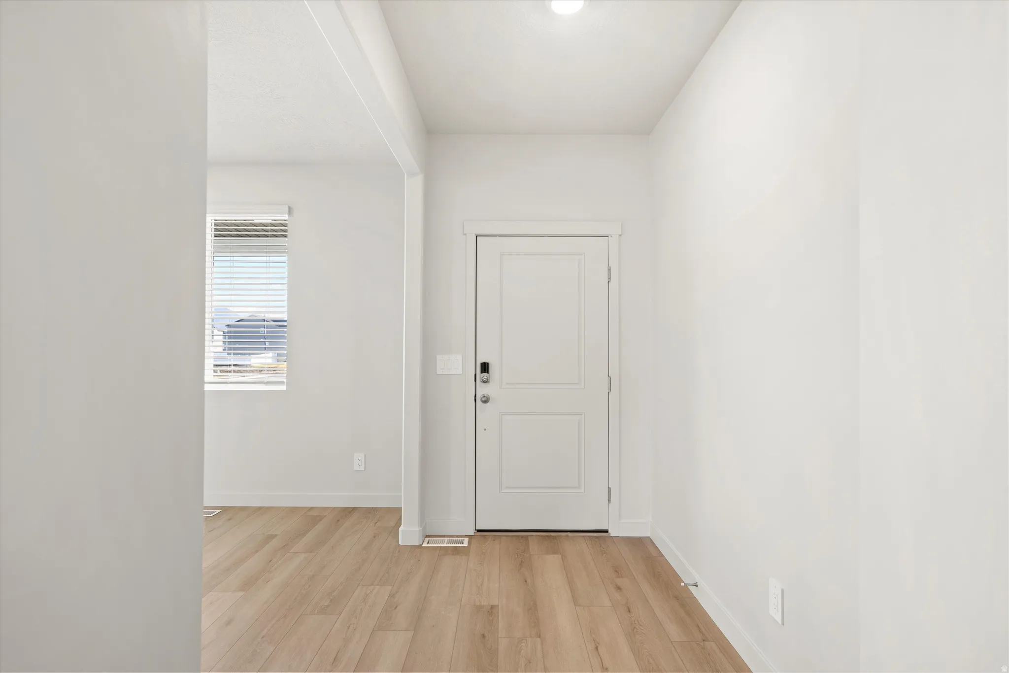 Doorway with wood finished floors and baseboards