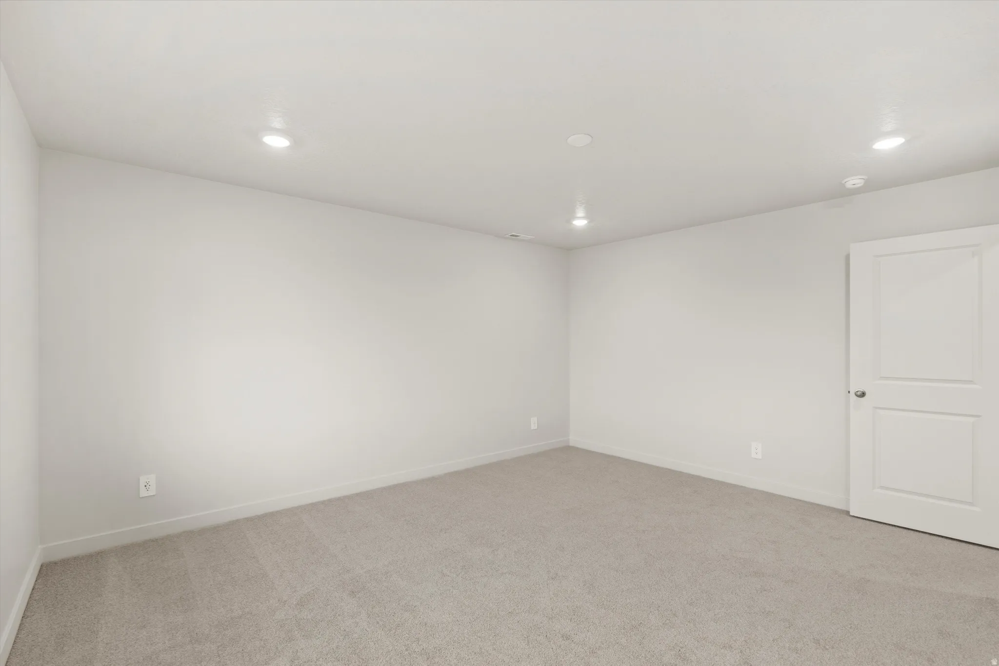 Unfurnished room with light colored carpet and recessed lighting