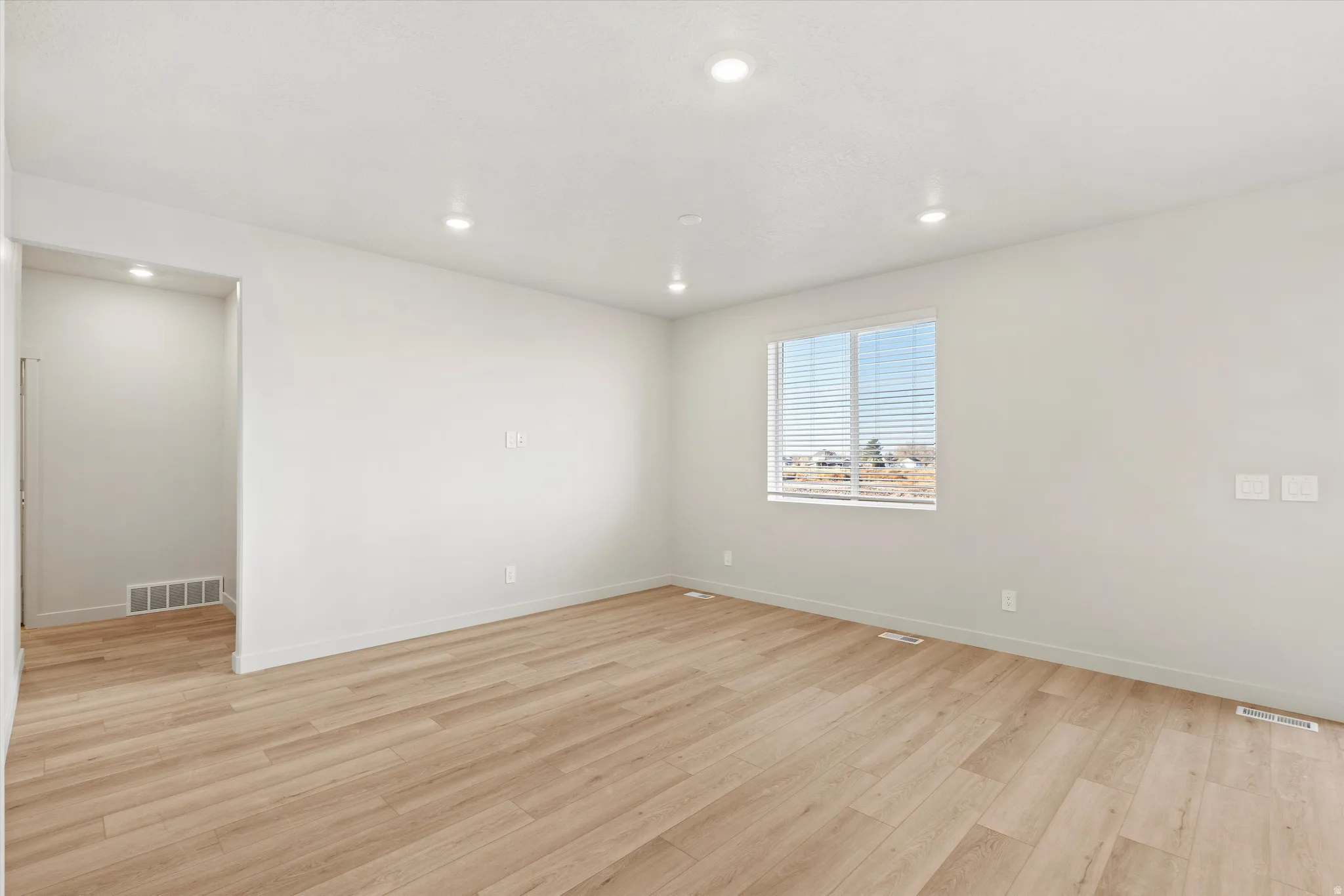 Spare room with light wood finished floors and recessed lighting