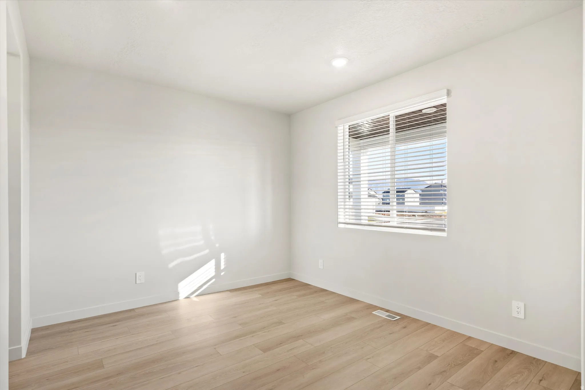 Unfurnished room with light wood-type flooring and baseboards