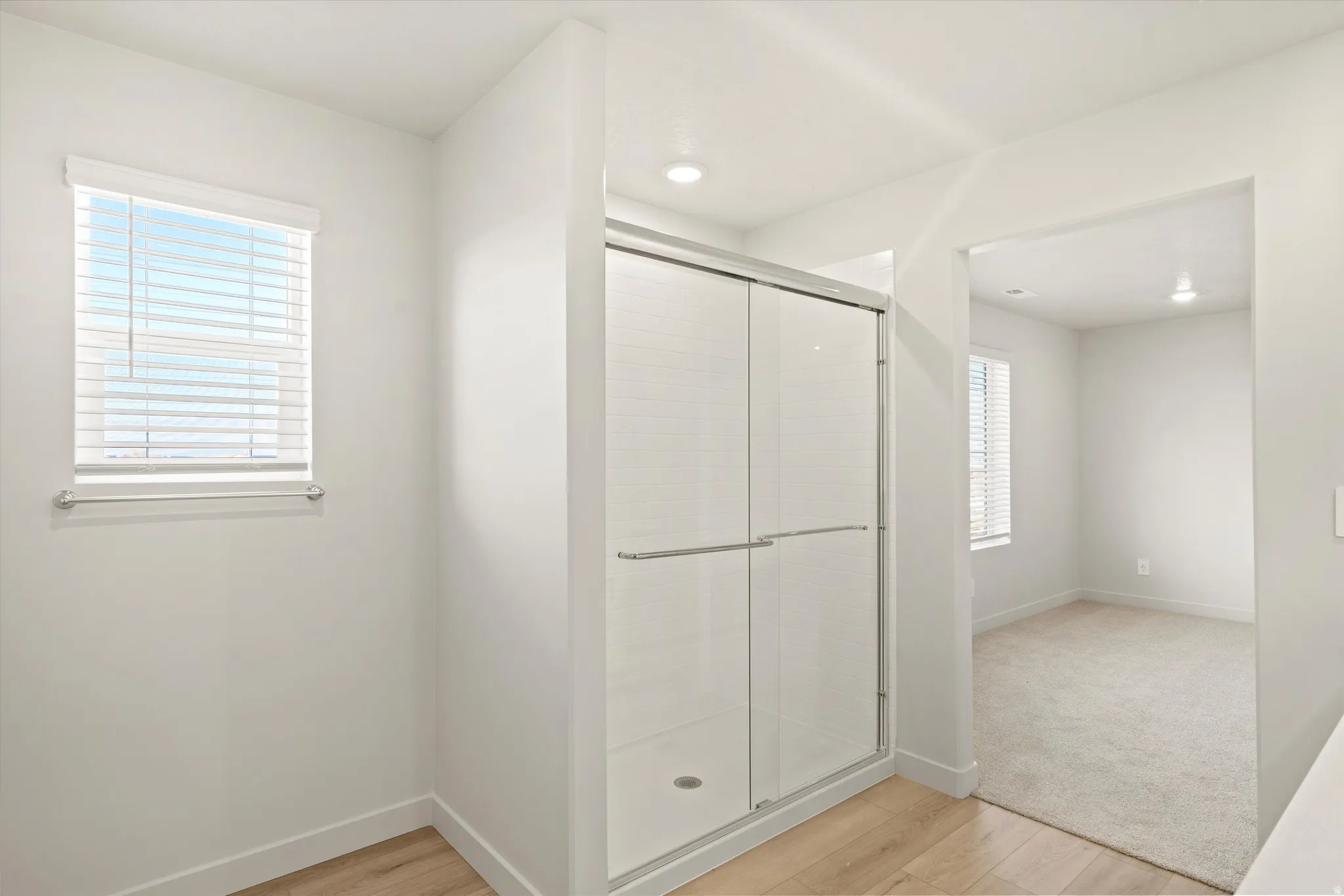 Full bathroom with light wood-style flooring and a stall shower