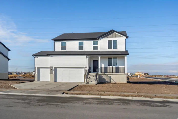 View of front of house featuring covered porch, concrete driveway, board and batten siding, and an attached garage