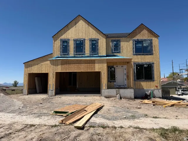 Two-story residential structure featuring multiple windows, a prominent front entry, and an integrated two-car garage