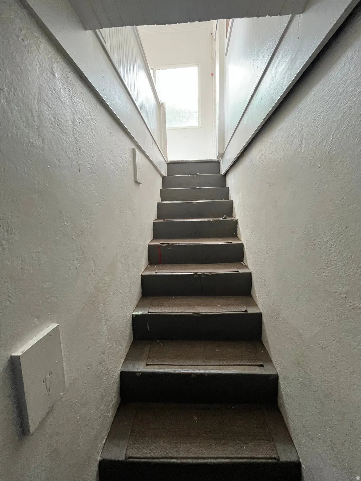 Stairway featuring a textured wall