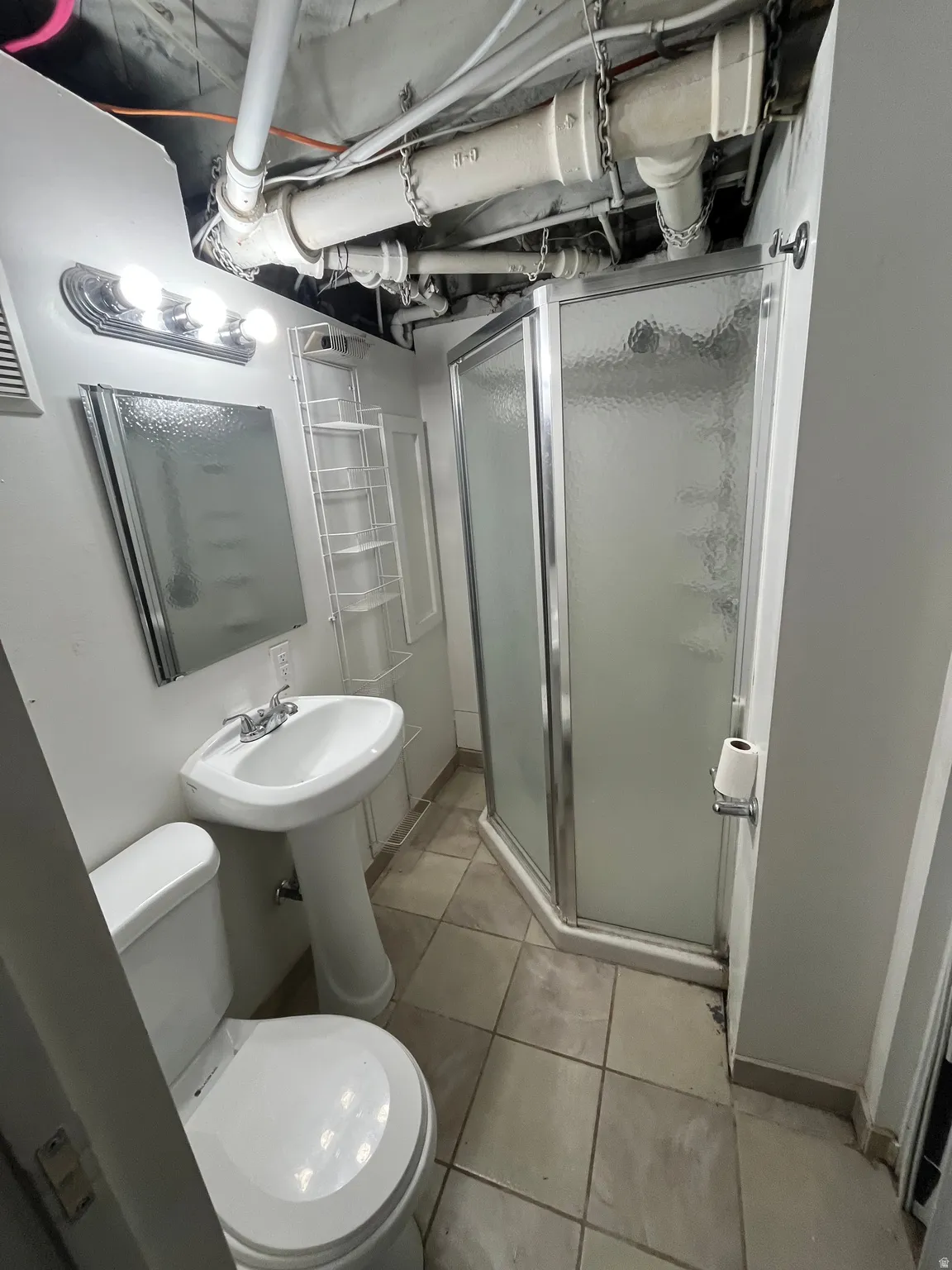 Bathroom with a stall shower and light tile patterned flooring