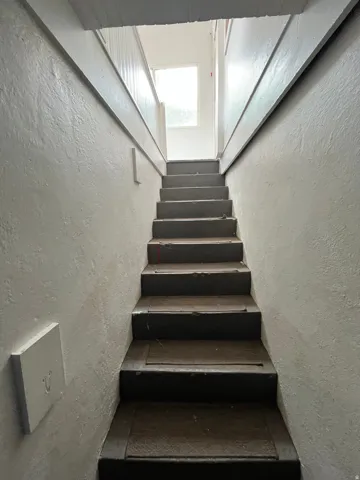 Stairway featuring a textured wall