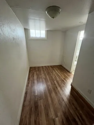 Unfurnished room featuring dark wood finished floors and baseboards