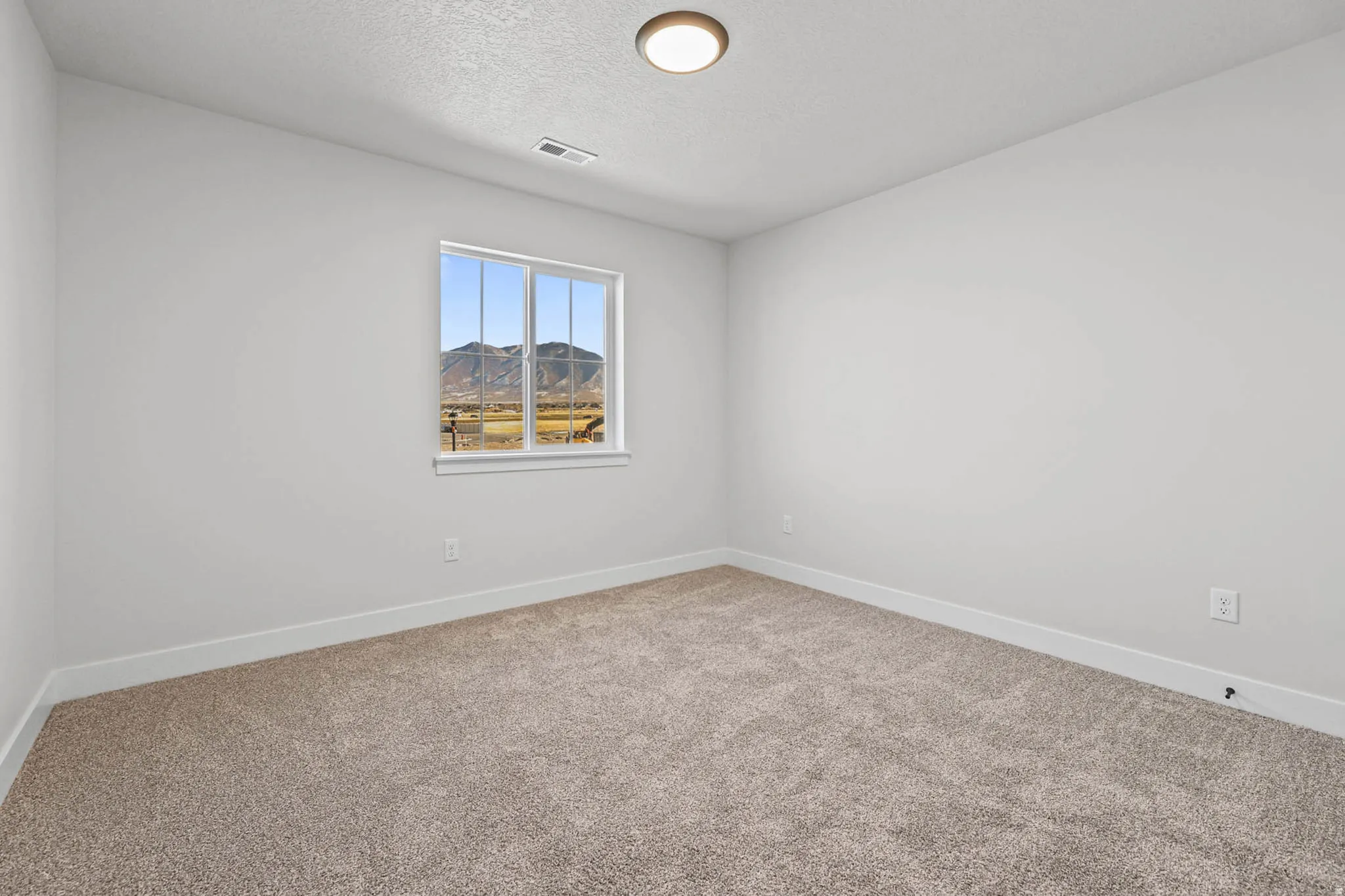 Carpeted empty room with baseboards and a textured ceiling