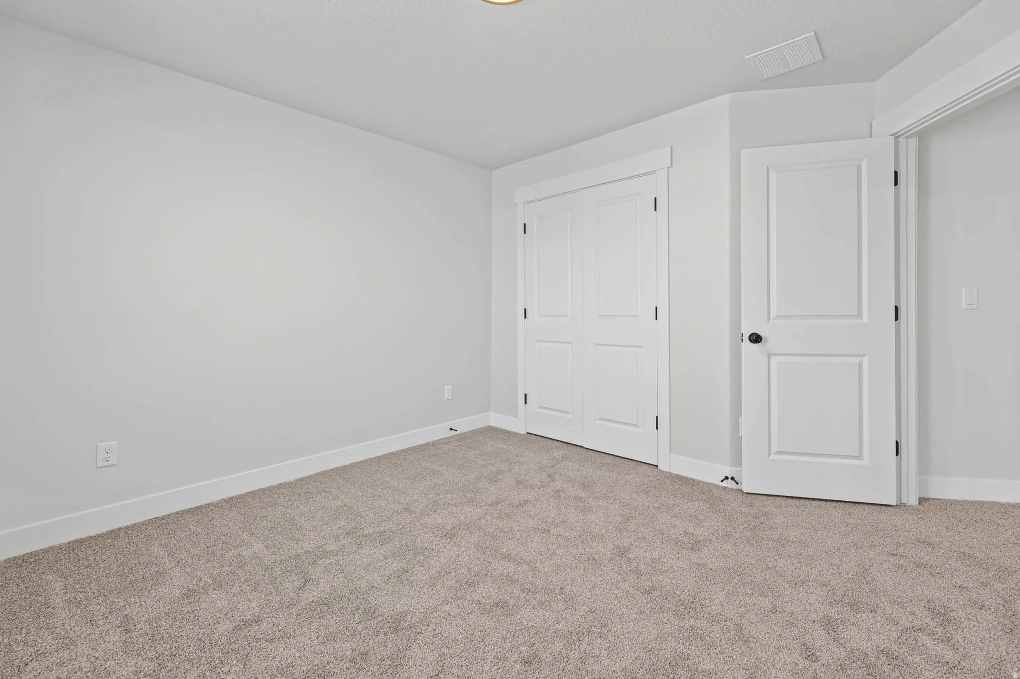 Unfurnished bedroom with carpet and a closet