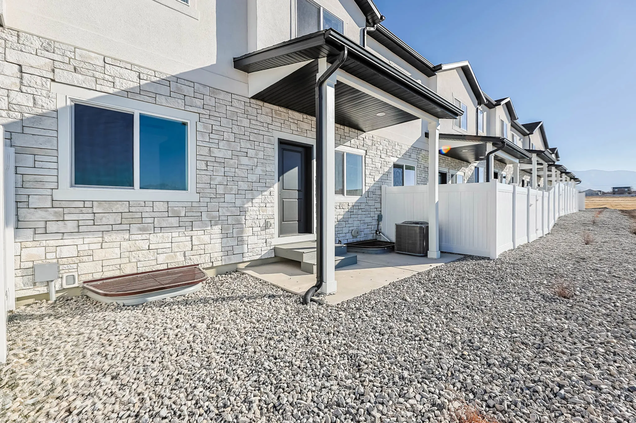 Property entrance with stone siding and a patio