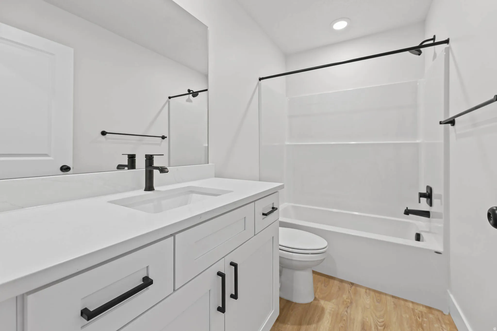 Bathroom with light wood-style flooring, vanity, and bathing tub / shower combination