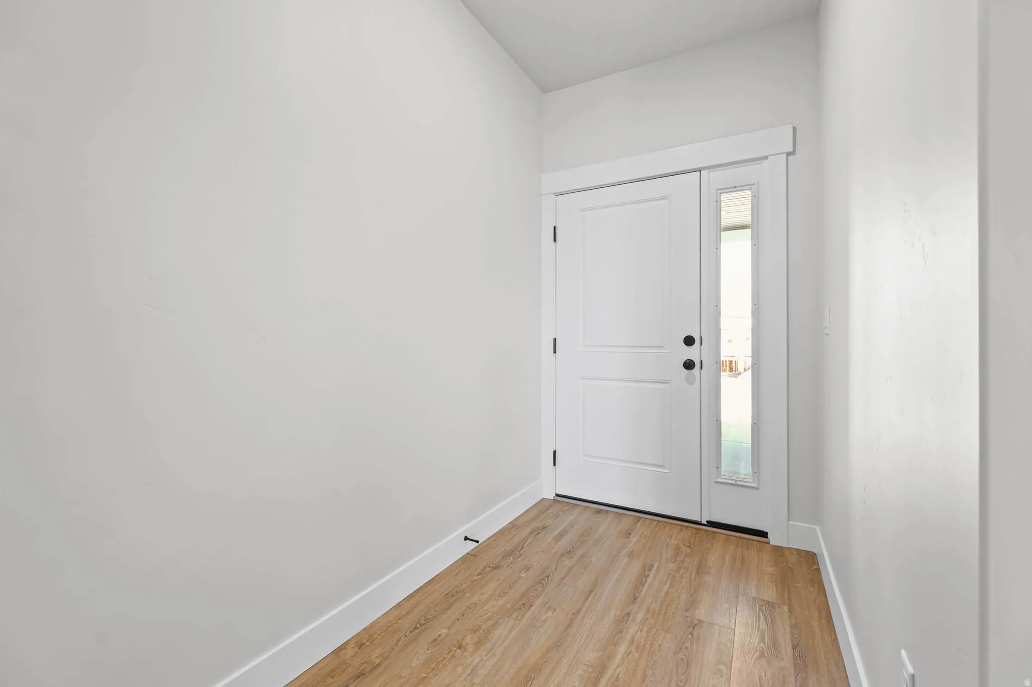 Entrance foyer with baseboards and light wood-style floors