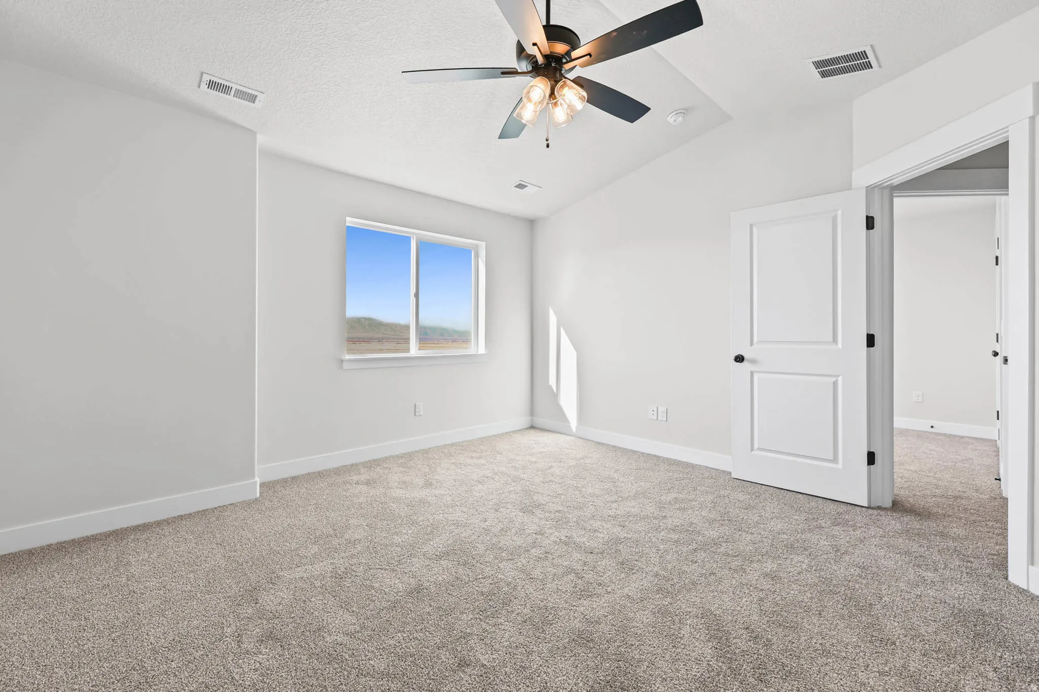 Unfurnished bedroom featuring light colored carpet and ceiling fan