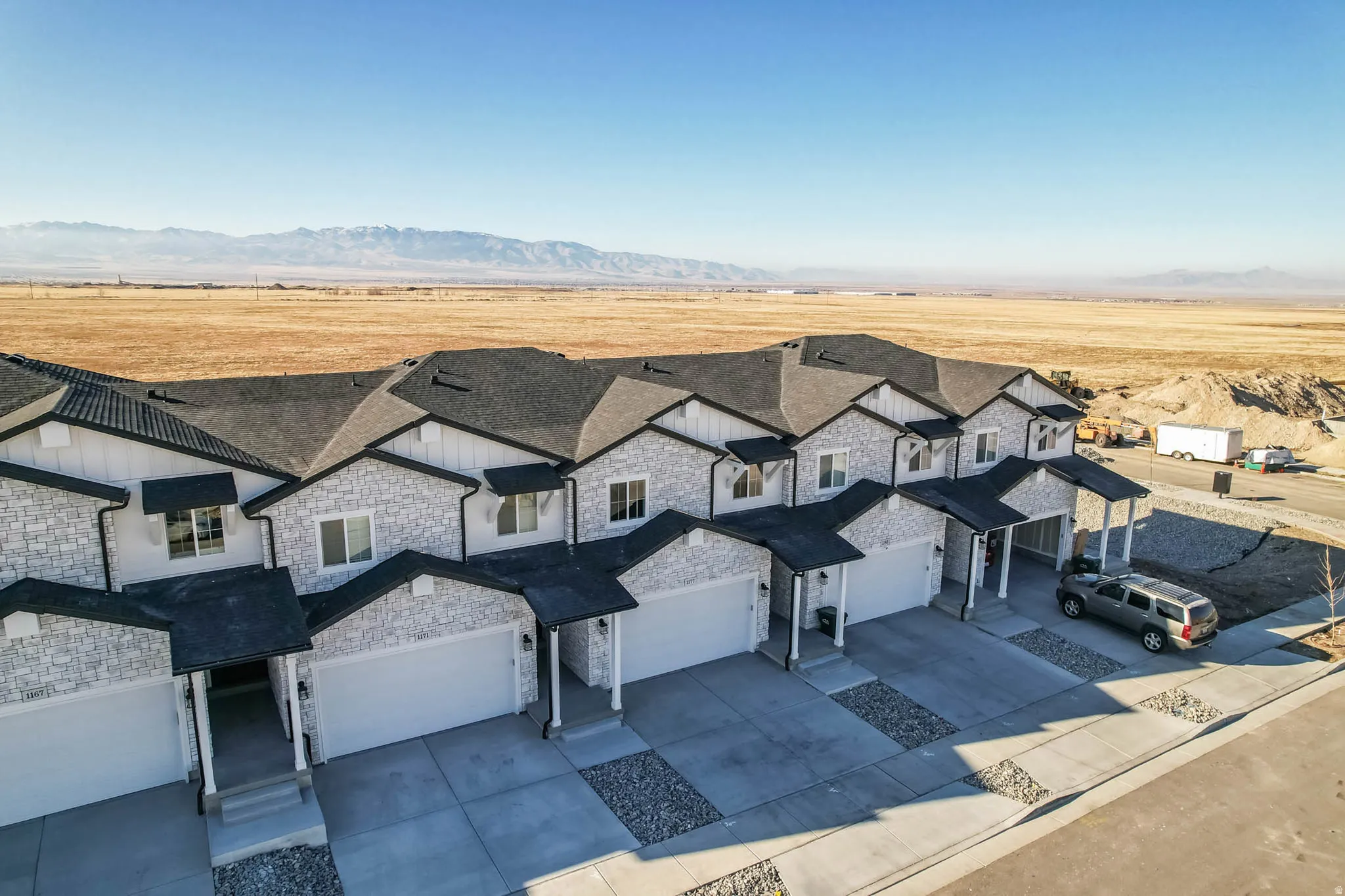 Aerial view of property and surrounding area featuring a mountain backdrop
