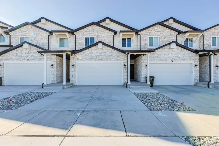 Craftsman house with concrete driveway, stone siding, and board and batten siding