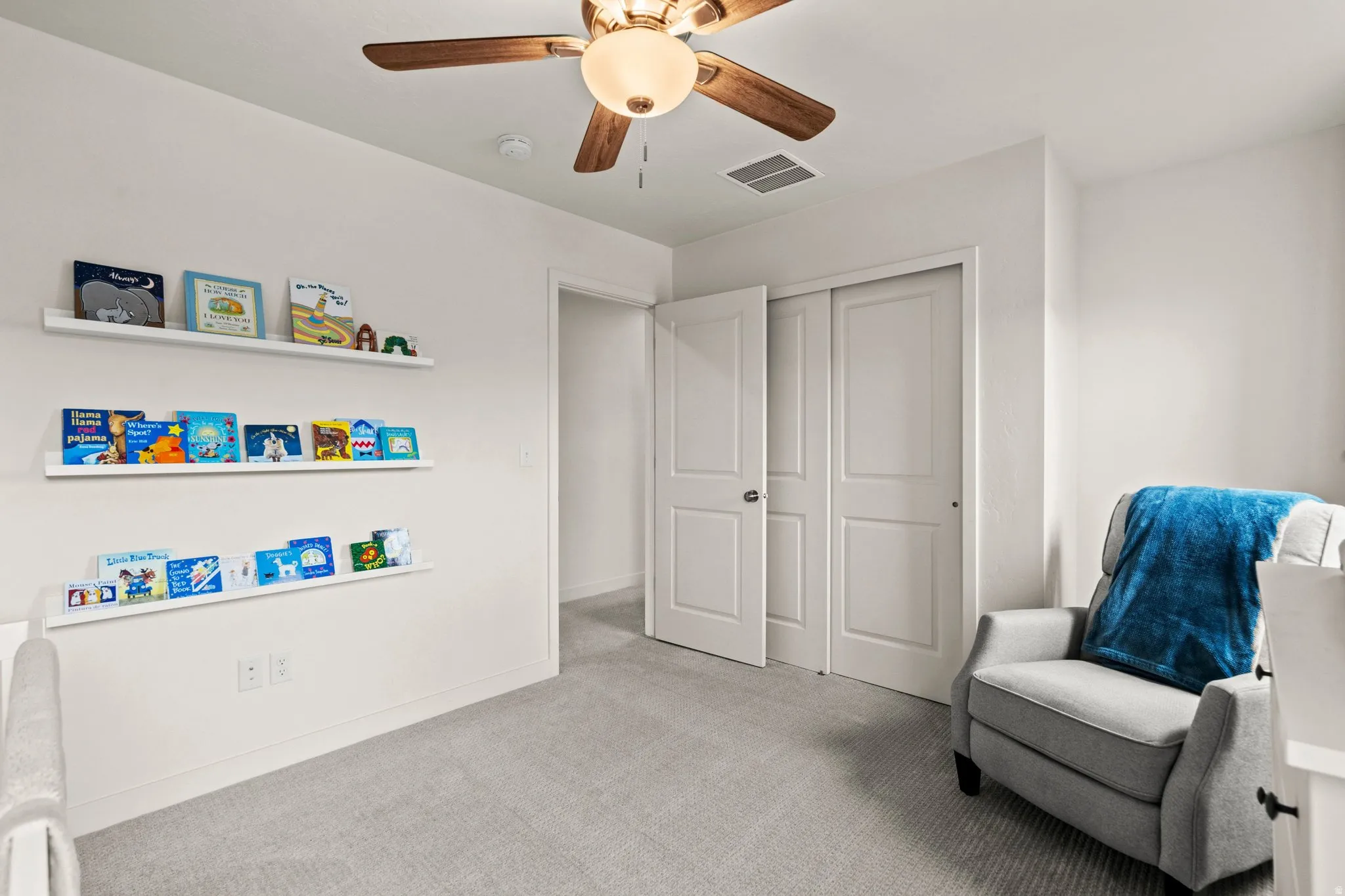 Living area featuring light carpet and a ceiling fan