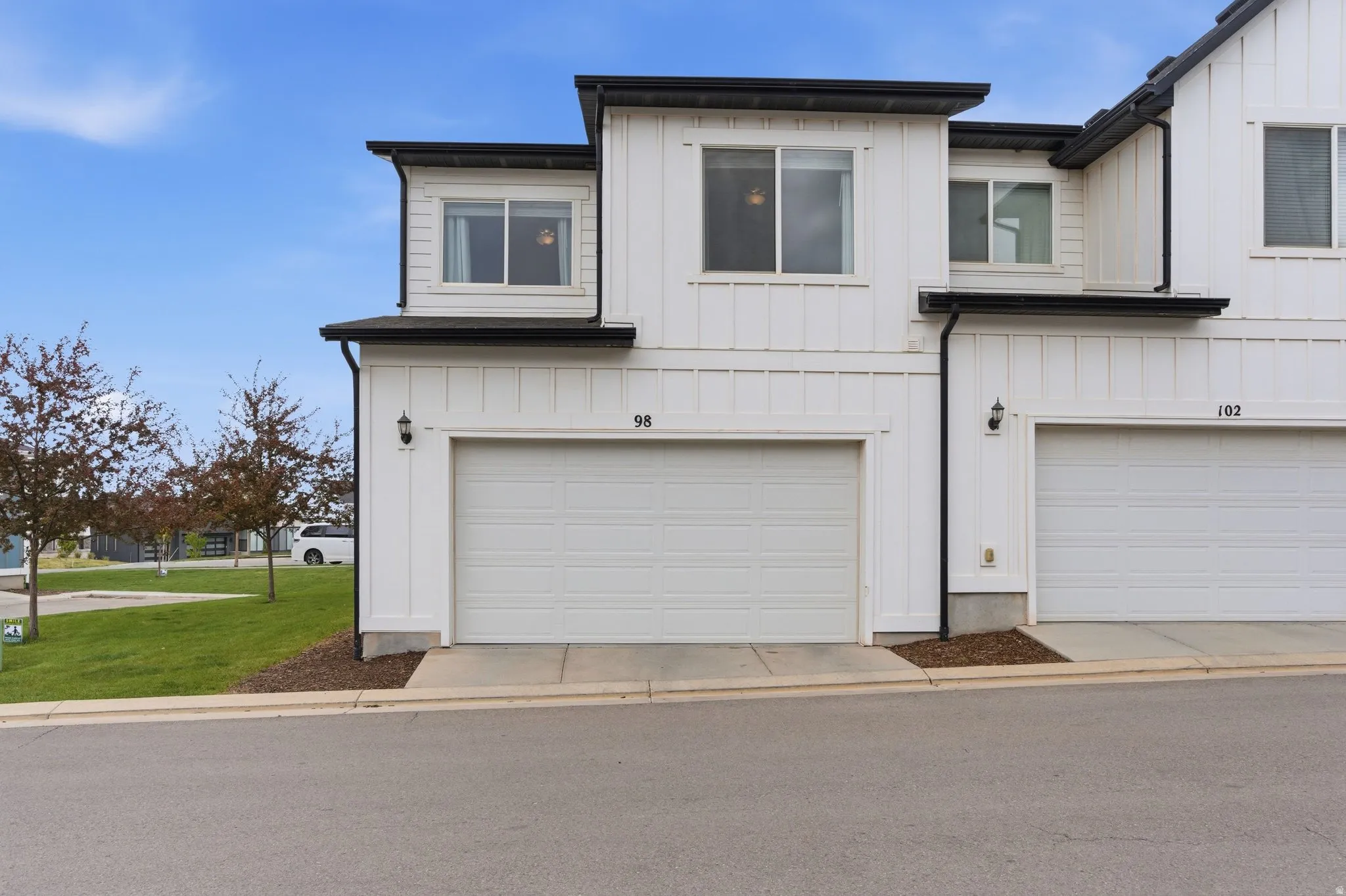 Modern farmhouse with board and batten siding, an attached garage, and concrete driveway