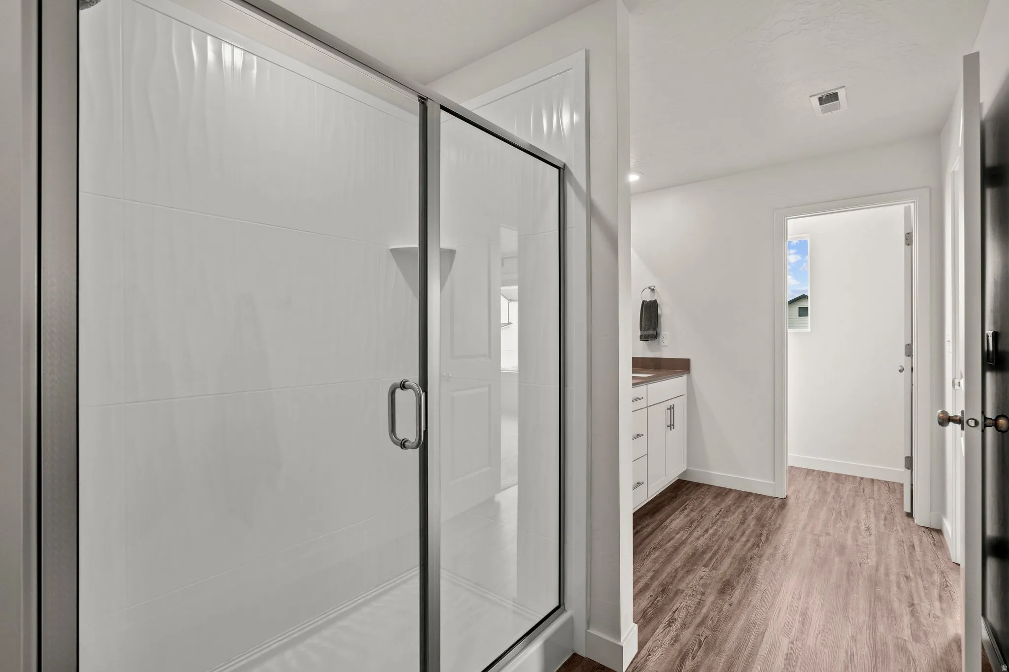 Full bath with vanity, a stall shower, dark wood finished floors, and recessed lighting