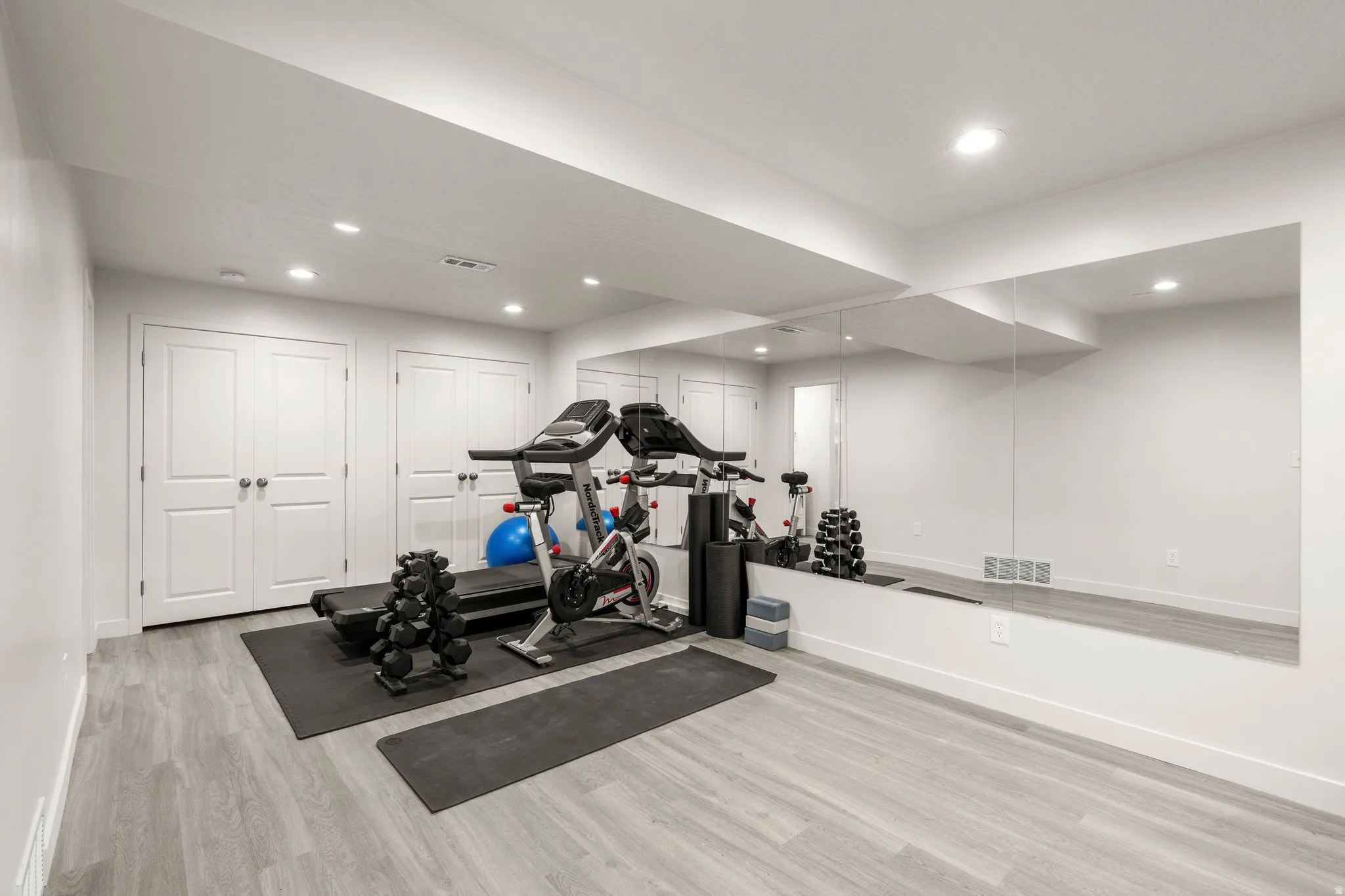 Workout room featuring light wood-type flooring and recessed lighting