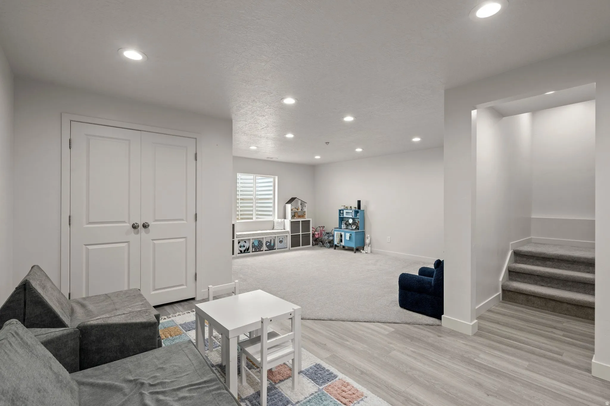 Living area with light wood-style floors, recessed lighting, and a textured ceiling