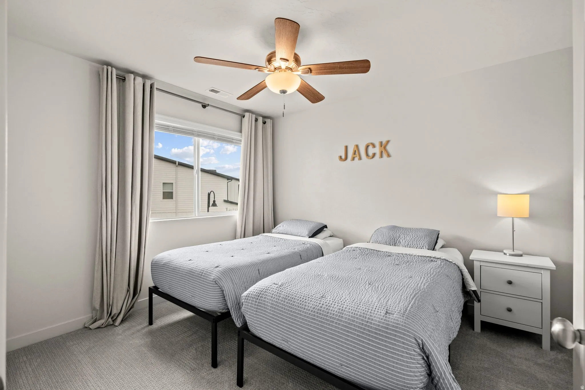 Carpeted bedroom with a ceiling fan and baseboards