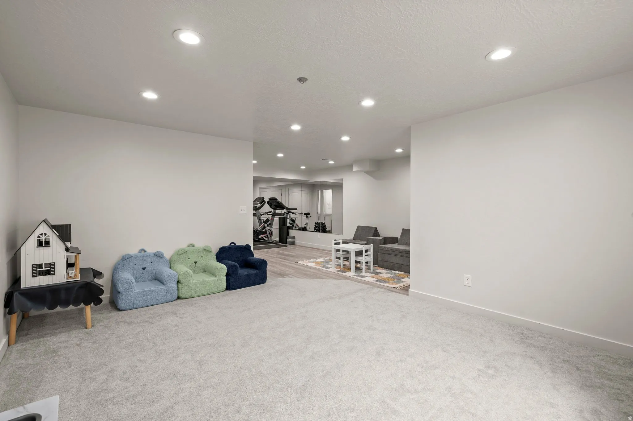 Living area featuring light colored carpet and recessed lighting