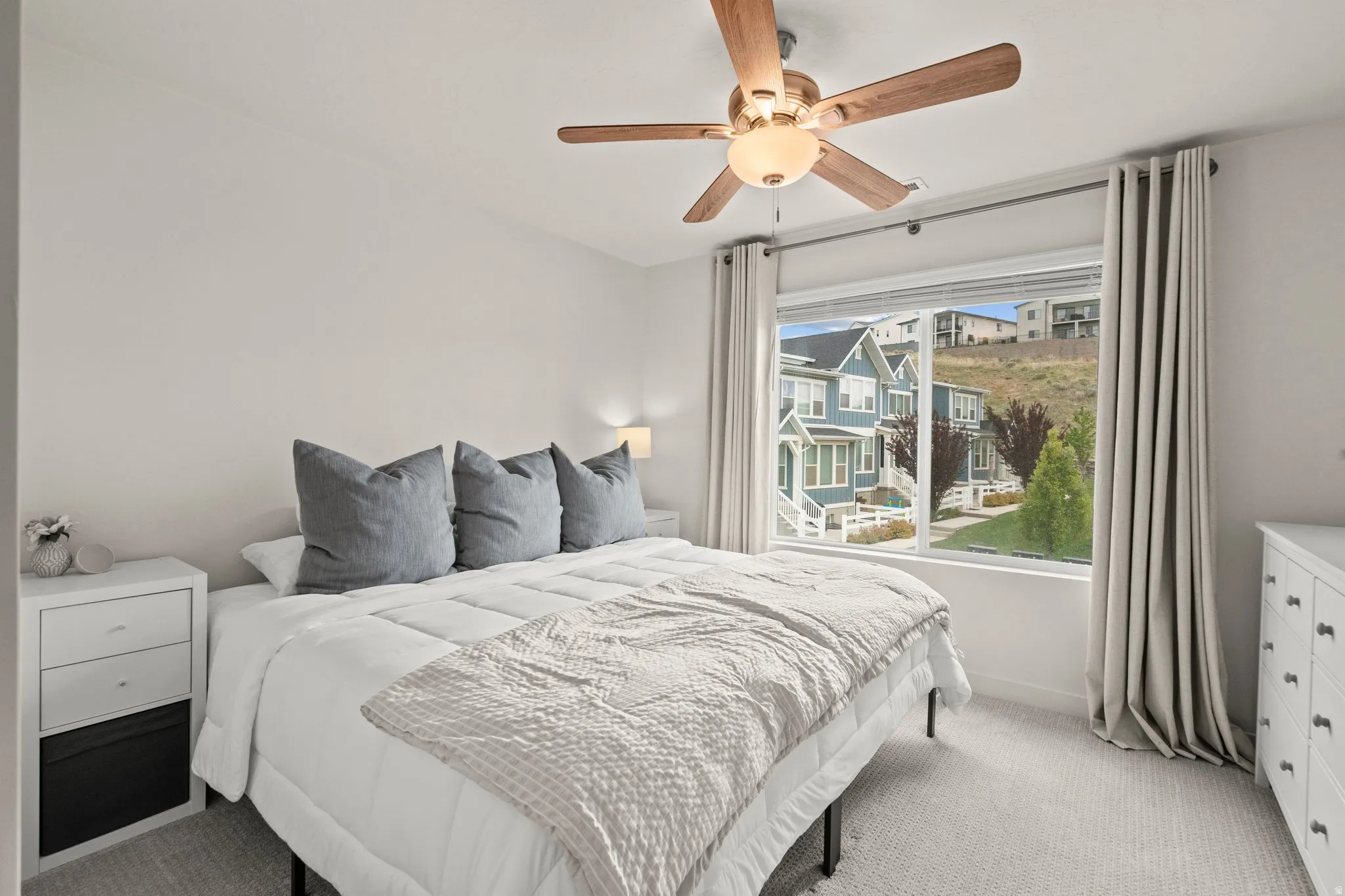 Carpeted bedroom featuring ceiling fan and baseboards