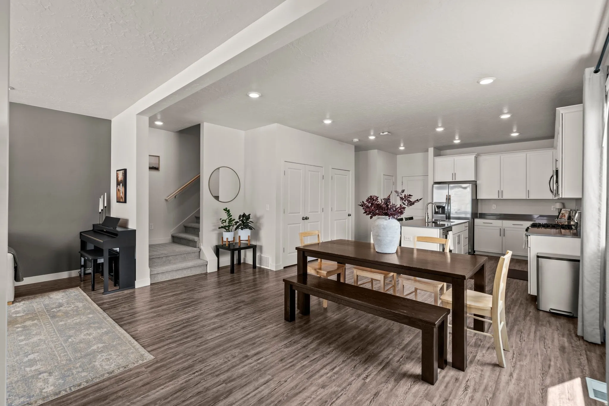 Dining room featuring dark wood-type flooring, recessed lighting, and a textured ceiling