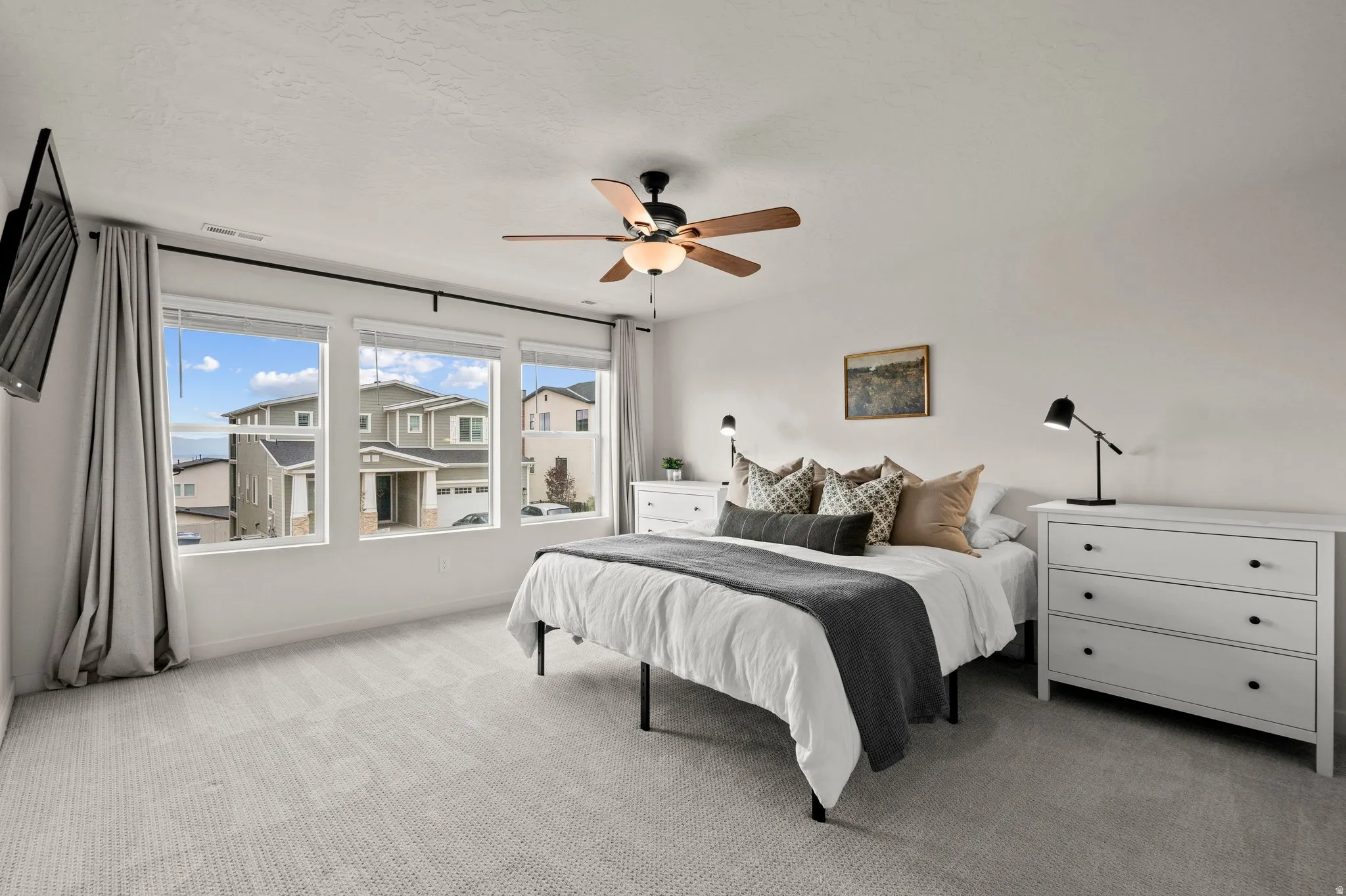 Bedroom with light colored carpet and a ceiling fan