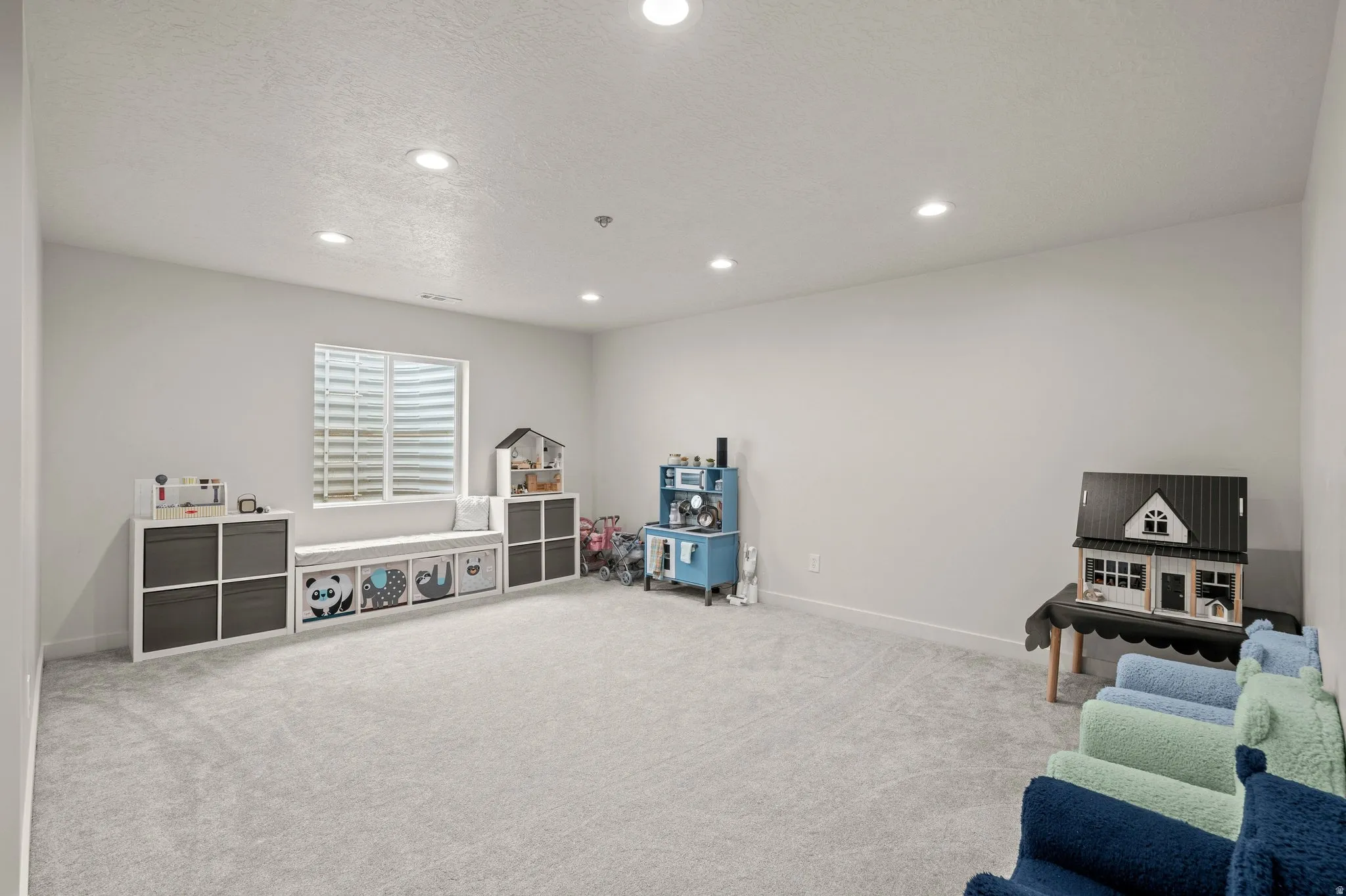 Rec room featuring recessed lighting, light colored carpet, and a textured ceiling