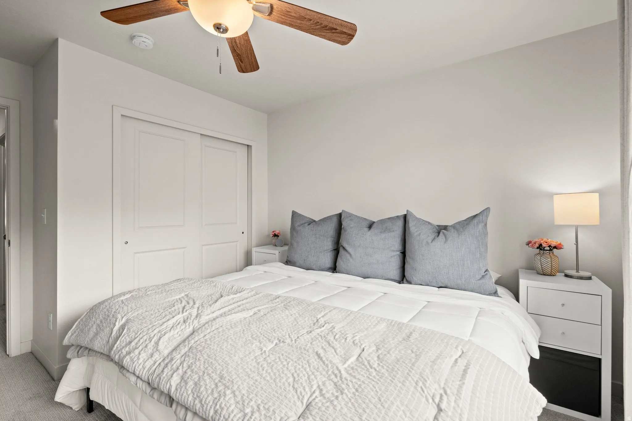 Carpeted bedroom with a closet and a ceiling fan
