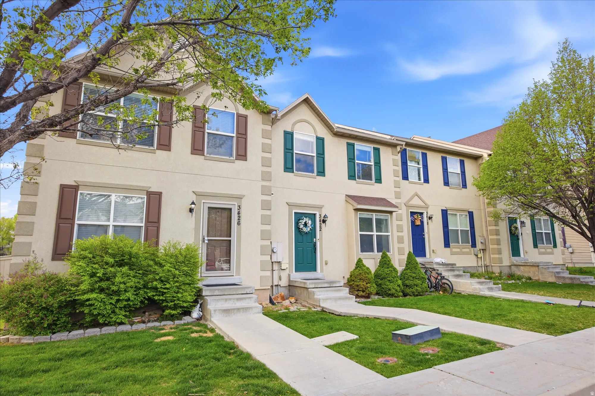 View of front of home featuring a front lawn, stucco siding, and entry steps