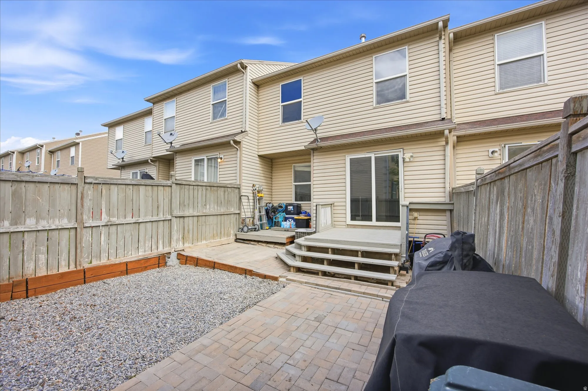 Back of house featuring a fenced backyard, a deck, and a residential view