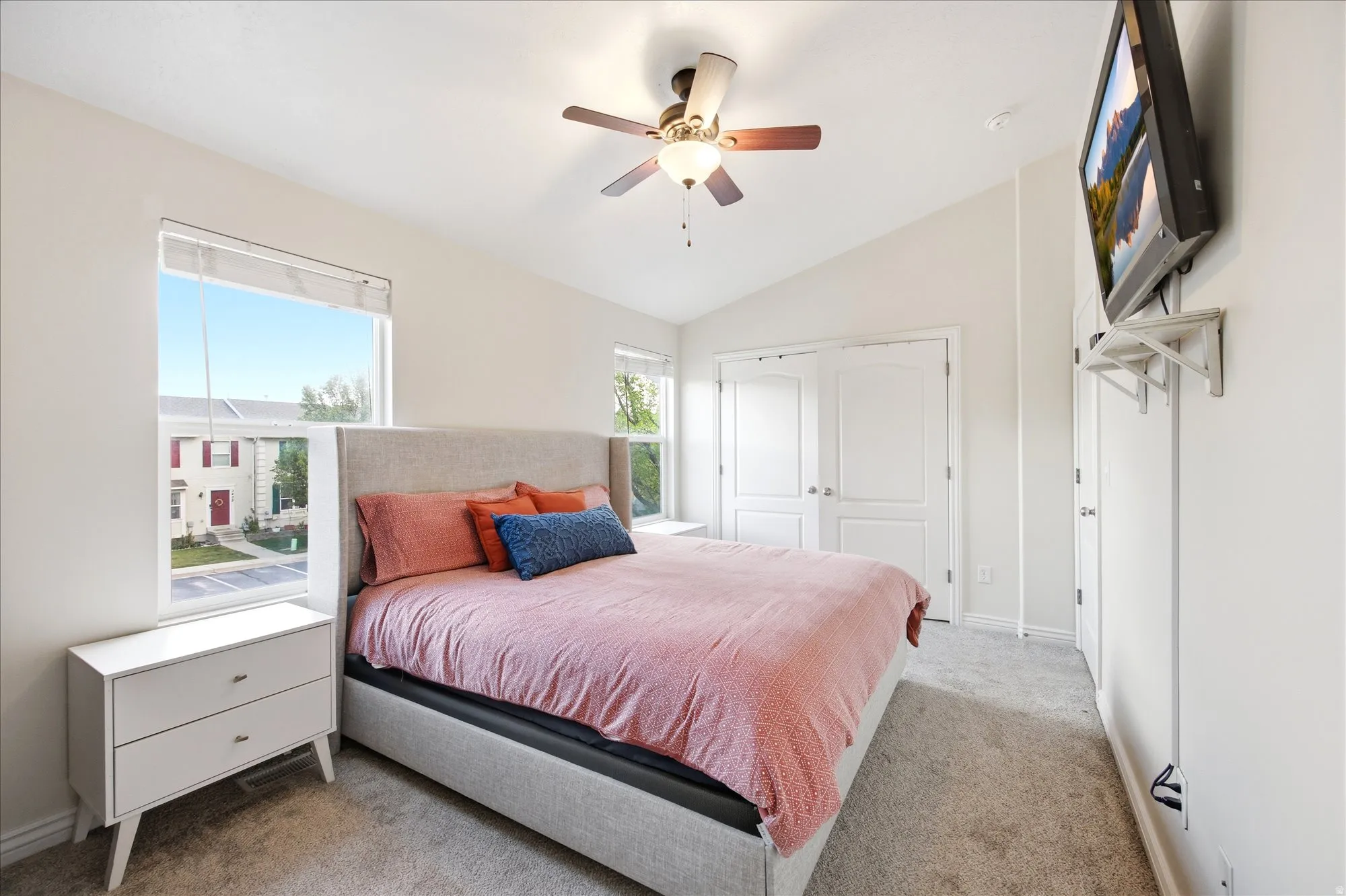 Bedroom featuring lofted ceiling, light colored carpet, a closet, and ceiling fan