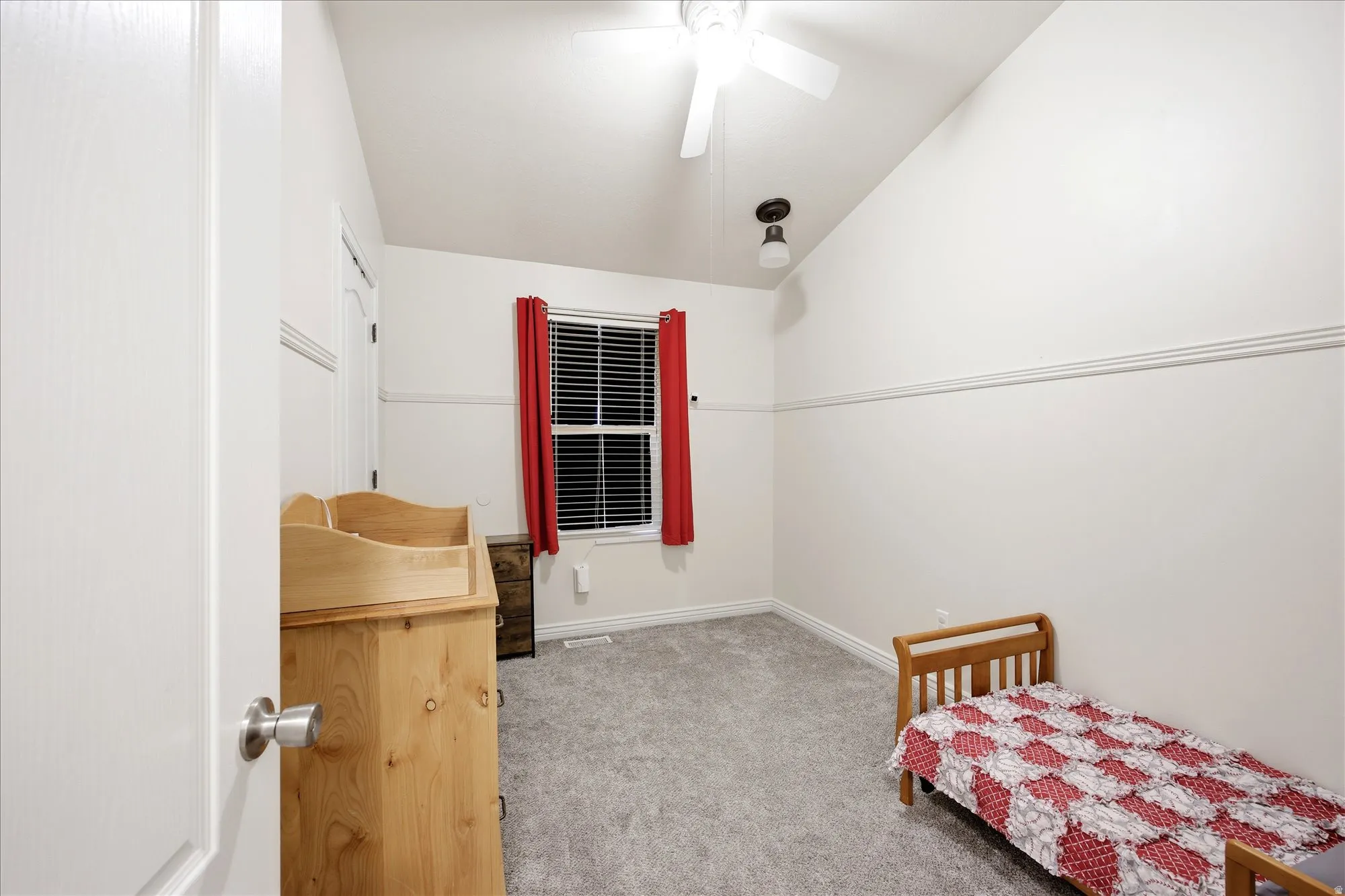 Bedroom featuring vaulted ceiling, light colored carpet, and a ceiling fan