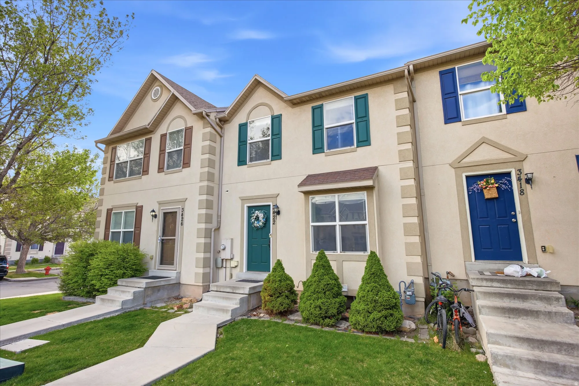 Traditional-style home with stucco siding, a front yard, and entry steps