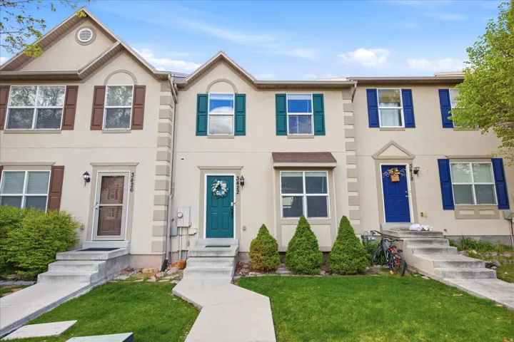 View of front of home featuring stucco siding and a front lawn