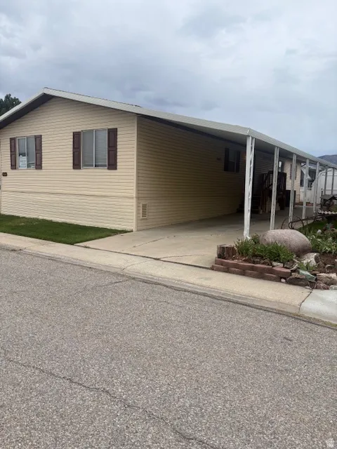 View of front of property featuring an attached carport and concrete driveway