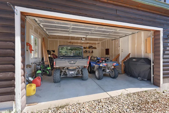 Spacious garage featuring a concrete floor, interior window, and interior access door