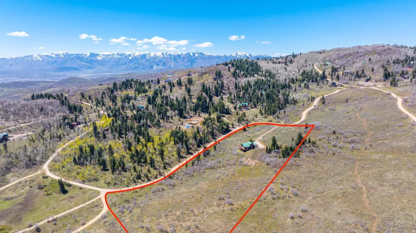 Expansive property outlined in red, featuring a single dwelling amidst natural terrain and scattered trees