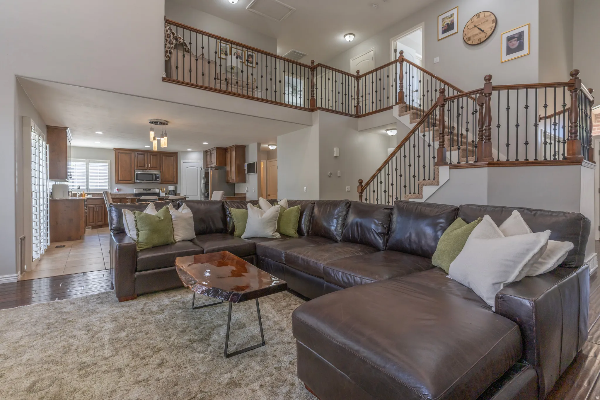 Living room featuring a high ceiling, recessed lighting, and light wood-type flooring
