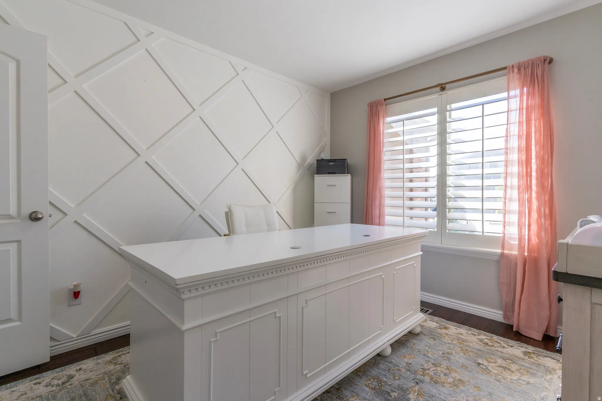 Home office featuring dark wood-type flooring and baseboards