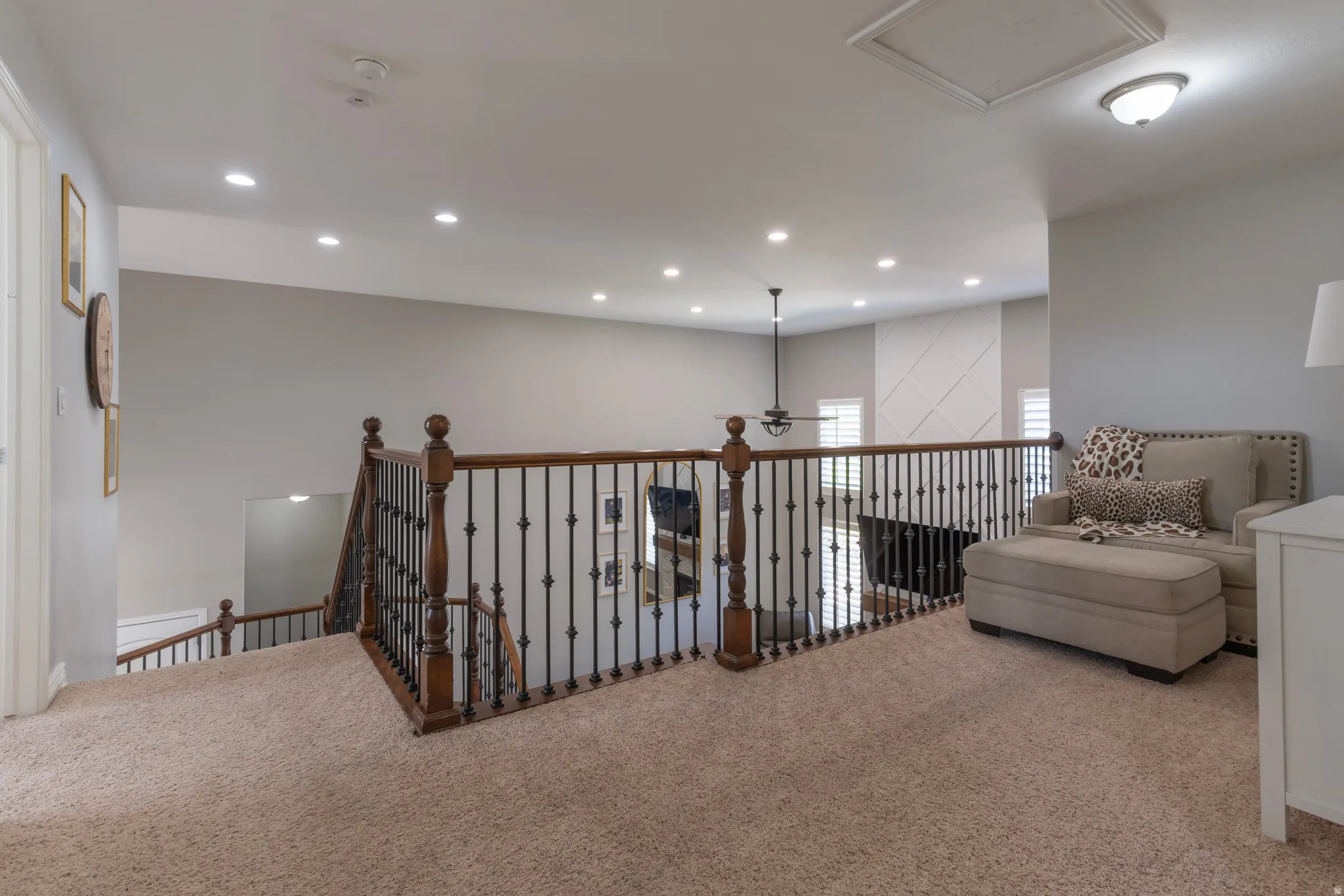 Living area featuring carpet floors, recessed lighting, and an upstairs landing