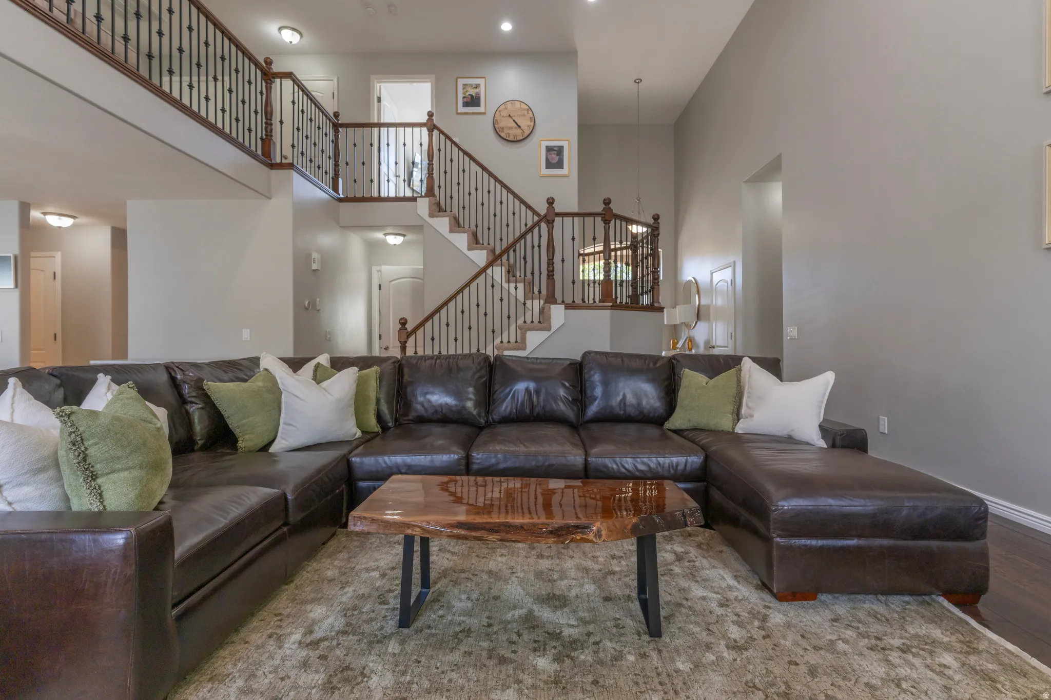 Living area featuring a high ceiling, wood finished floors, and recessed lighting